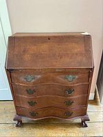 Front view of solid wood drop front secretary desk showing all three drawers and drop front closed