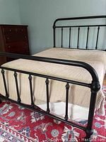 Full bed frame assembled in room with quilts and dresser in background