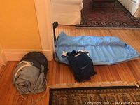 Lazy Nap child-sized blow-up bed partially inflated on floor, with carrying bag beside it.