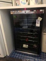 Front view of cooler showing glass door, stainless steel trim and interior racks