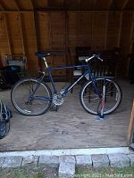 Full side view of blue Diamond Back Apex mountain bike on shed floor with Blackburn pump