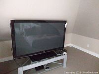 Front view of TV on glass and metal stand in room