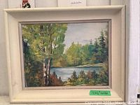 Original framed landscape painting featuring a pond and green trees with worn off-white wooden frame.