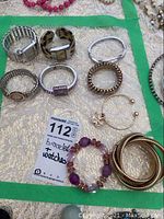 Photo showing full set of 5 bracelets and 4 watches arranged on surface with green border, selling tag included.