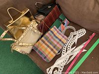Overview of multiple purses and belts arranged on a surface revealing colors, styles, and materials.