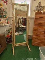Front view of the standing swivel wooden frame mirror, showing the tall rectangular mirror and sturdy base.