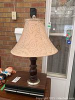 Front view of the table lamp showing wooden base and fabric shade with swirl pattern