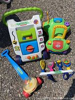 Photo showing children's white and green activity walker with blocks and poppers, green and yellow interactive ride-on car, blue push toy with clear spinning dome, and colorful toy instrument set with Velcro.