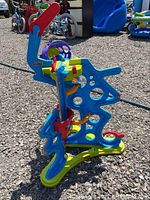 Photo of colorful Fisher Price Spinyos activity center with dinosaur shape and interactive parts.