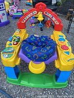 Front view of Fisher Price Intellitainer baby activity center showing colorful play elements, arch, and fabric seat.