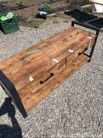 Full view of wooden entry bench with black metal frame, showing surface damage and tape residue on top and two drawers with metal handles.
