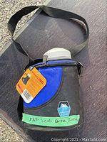 Insulated carrier with strap and visible Arctic Zone logo and handwritten label on green tape.