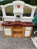 Front view of Step 2 play kitchen showing stove burners, sink, oven, and dishwasher doors closed