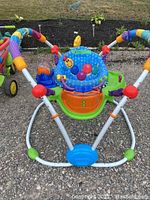 Front view of the Baby Einstein Jumperoo showing colorful padded seat, support frame, and toy attachments.