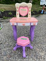 Front view of child's vanity with heart-shaped mirror and matching stool.