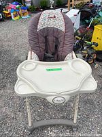 Front view of Safety 1st high chair showing padded seat with printed headrest, white removable tray with cup holders.