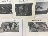 Close-up of the covers of four books showing famous black and white photos by Henri Cartier-Bresson, Wynn Bullock, Man Ray, and August Sander.