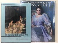 Two large hardcover art books about John Singer Sargent, positioned side by side, one with a light blue cover and one with a dark cover showing a woman in a lavender dress.