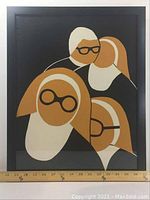 Frontal view of the framed poster showing the full artwork of four stylized heads with glasses