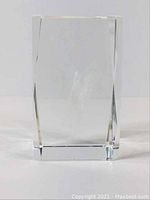 Clear solid crystal glass cube, front view showing the smooth facets and minor nicks on surface.