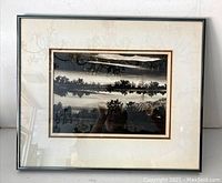 Full view of the framed artwork showing the piece and its matting inside a black frame under glass.