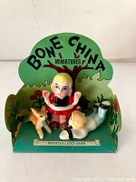 Front view of Jack and Jill bone china miniatures on green cardboard display stand with 'BONE CHINA MINIATURES' text