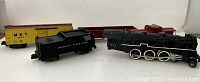 Overview of all five American Flyer toy train cars showing locomotive, tender, boxcar, caboose, and another car.