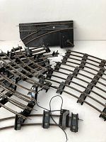 Collection of metal toy train tracks and switches from American Flyer, arranged with some curved and straight pieces as well as switch components.
