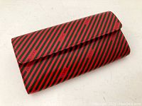 Front angled view of the vintage Gucci wallet showcasing red and green diagonal stripes with Gucci logo