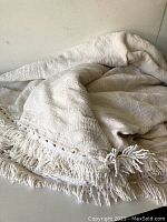 Full view of the vintage white woven blanket with fringe, showing texture and size.