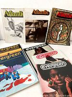 Photo showing six vintage magazines: three Atlantic magazines with varied covers including the 'Women's Rights' issue and three Evergreen Review magazines with illustrated and photographic covers from 1969 and 1970.