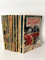 Side view of the 12 magazines showing distinct cover art and slight wear on edges