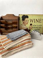 Photo showing woven placemats, folded blue napkins, wooden letter holder, tin sign, and metal napkin holder.