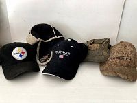 Lot of five hats arranged in a row showing various styles and wear.