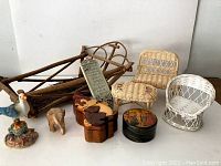 Lot of 9 miniature wicker furniture pieces, various small figurines, a wooden puzzle box, a wooden sled decoration, a round painted box, and a Campbell's Soup can used for decor.