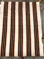 Full view of one of the runners showing the vertical striped pattern in black, brown, and beige.