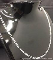Front view of the sterling silver Figaro link necklace displayed on a black mannequin bust showing the classic Figaro pattern chain links against a dark background.