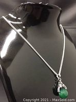 Necklace displayed on black mannequin focusing on chain and pendant drape.