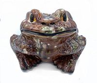 Front view of brown glossy porcelain garden frog figurine with detailed texture and realistic eyes.