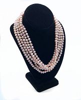Strand of natural pink Akoya pearls displayed on a black bust stand showing off the color and multi-strand appearance.