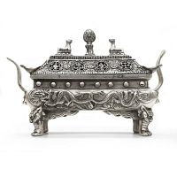 Front view of the silver incense burner showing dragon decoration on the base and detailed lid with animal finials.