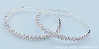 Pair of sterling silver hoop earrings embellished with clear CZ diamonds, photographed on a white background.
