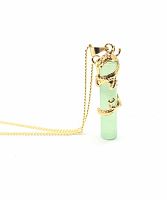 Close up of green jade cylindrical pendant with a gold dragon wrapped around it, shown hanging on snake link gold-tone necklace.