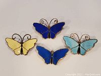 Front view of all four butterfly pins laid out together.