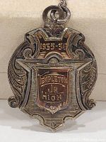 Close-up front view of 1935-36 Templeton Jr High pendant with gold plaque and silver ornate design