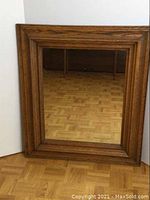 Front view of the rectangular antique oak frame mirror showing the wood grain and mirror surface.