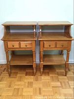 Pair of Vilas end tables shown from the front, both tables appear identical with two drawers, open shelf, and top raised compartment with curved sides.
