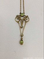 Full front view on white fabric background showing pendant and chain.