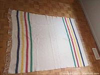 Full view of the Hudson Bay Caribou wool rug laid out flat showing color stripes and fringed edges.