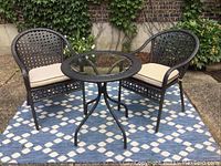 Overall view of set with table and two chairs on outdoor rug
